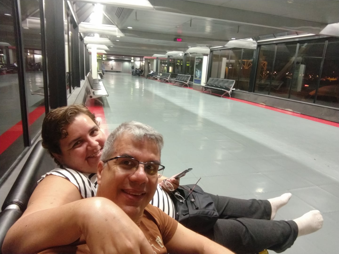 Casal no corredor vazio de um aeroporto